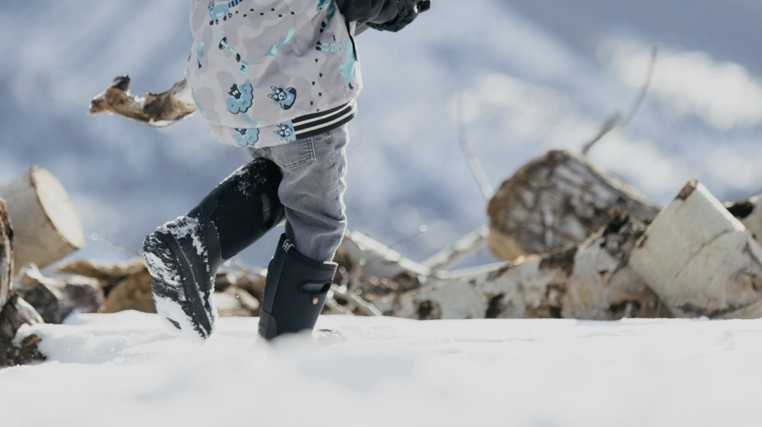 Click to shop Kids' winter boots. Image features the Kids' Classic boot in black in the snow.