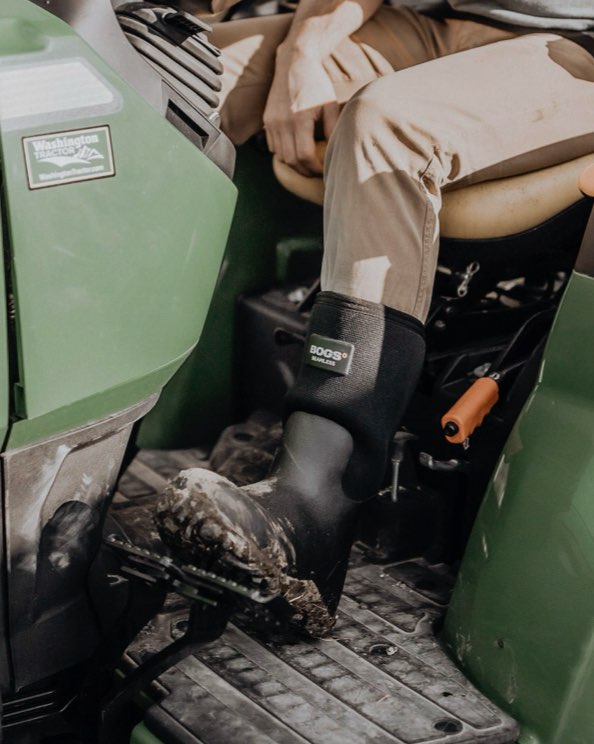 Click to shop men's Workman boots. Image features the style on a green tractor.