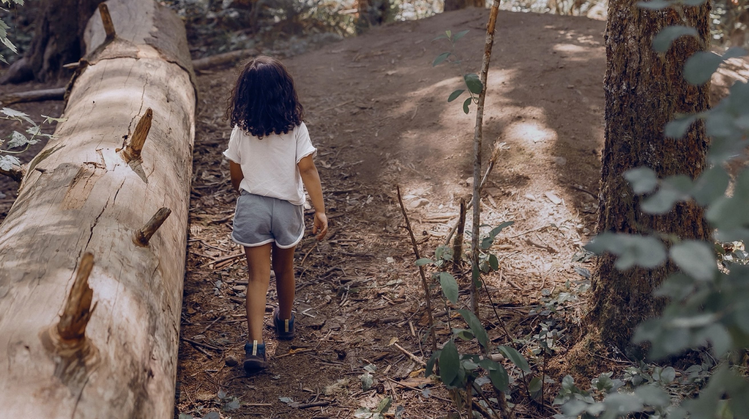 Shop our casual Kids' Skyline Kicker shoes.  The image shown is girl exploring a wooden area. The boot highlighted our Kids' Skyline Kicker shoes in a variety of colors.