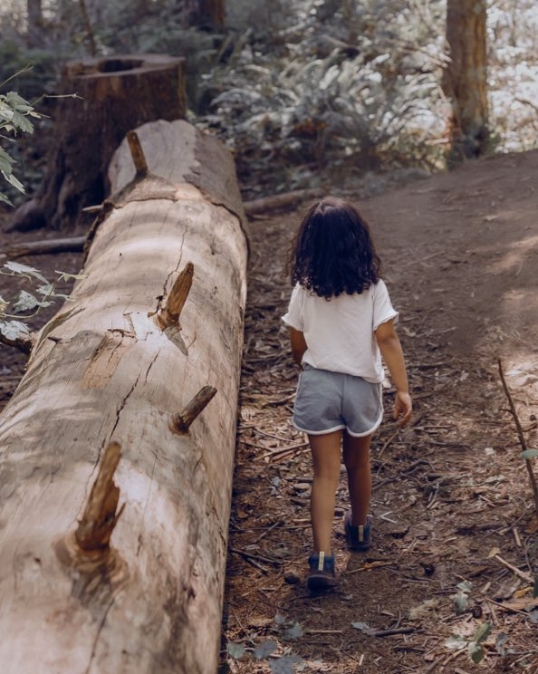 Shop our casual Kids' Skyline Kicker shoes.  The image shown is girl exploring a wooden area. The boot highlighted our Kids' Skyline Kicker shoes in a variety of colors.