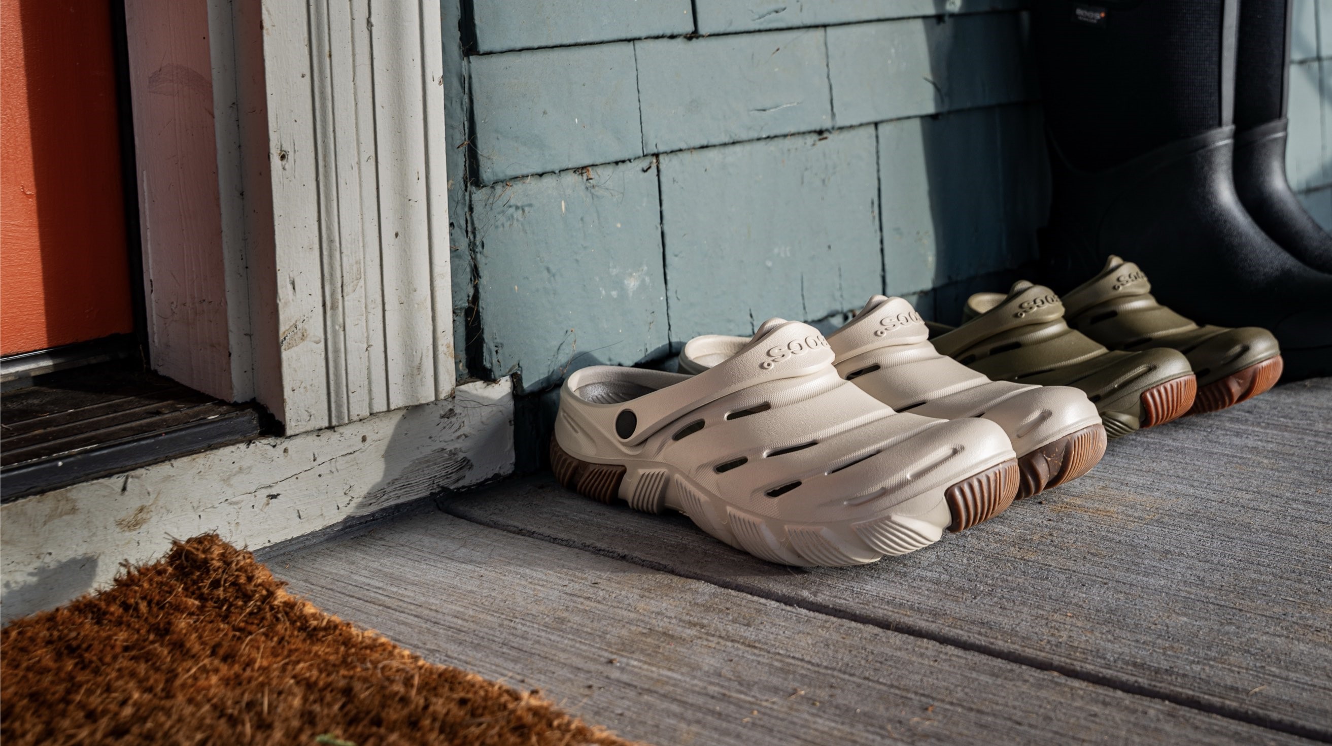 Shop our Men's & Women's Boga casual slip on boots. The image shown is our oatmeal and green colorways on a house porch