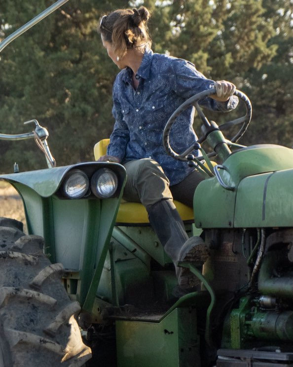 Click to shop women's work boots. Image features a woman on a tractor.