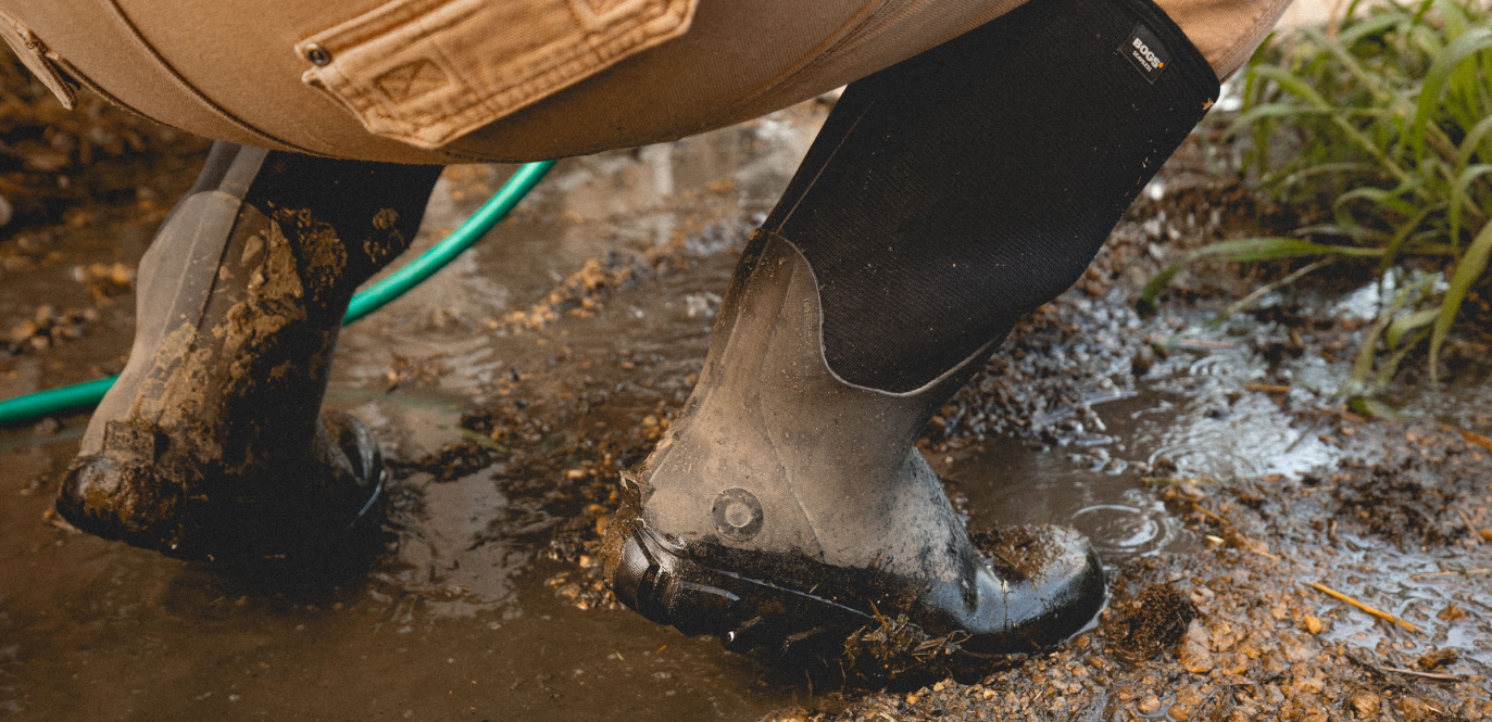 The closeup image shown is our Men's Classic Seamless boot tall in mud climbing up into a tractor.