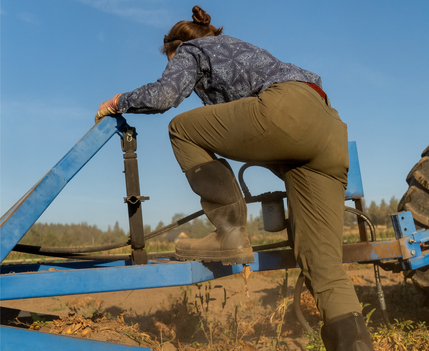 Shop our women's seamless boots. The image shown is a farmer stepping on to a trailer wearing the Classic Seamless tall.