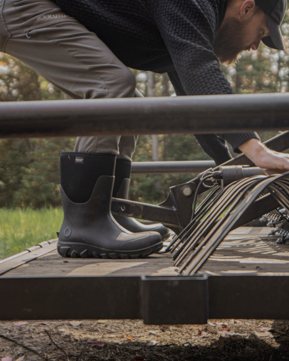 The image shown is a man examining equipment on a truck bed . The boots he is wearing are our Men’s Classic Seamless mid waterproof boots in black. Shop now.